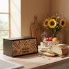 Wooden bread box with 'Always Baked Fresh' text on a kitchen counter with bread and fruit.