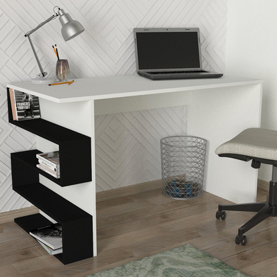 White study desk with black shelves, laptop, and lamp in a room with wooden floor and white wall.