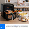 Black air fryer on a kitchen counter with various dishes, including vegetables and bread rolls.