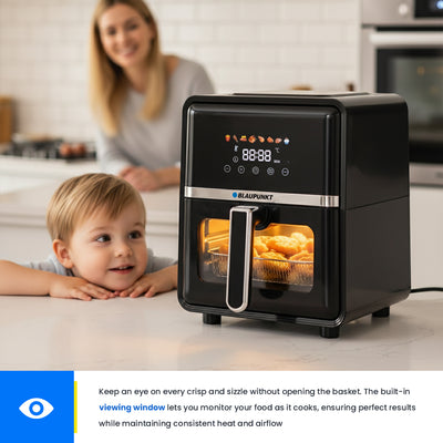 Black air fryer on a kitchen counter with a child and woman in the background
