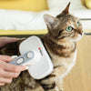 Cat being groomed with a Milex pet grooming brush on a light-colored surface.
