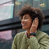 Woman wearing headphones with a blurred urban background, featuring the Polaroid logo.