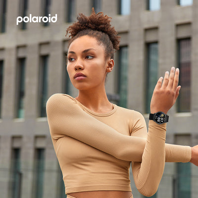 Woman wearing a Polaroid Bluetooth Calling Smart Watch with a blurred building background, featuring the Polaroid logo.