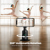 A black Polaroid handheld phone gimbal shown in a dance studio setting, with a smartphone mounted on top displaying a video call interface. Three ballerina dancers are visible in the background, and text at the bottom reads '360° Automatic Rotation' with a circular rotation graphic around the gimbal base.