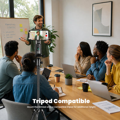 A man stands at the head of a meeting table holding a smartphone on a tripod, speaking to a group of colleagues who are seated around him with laptops and notebooks. The image includes the text 'Tripod Compatible' and a smaller subtitle about mounting the climber on a compatible tripod for additional height.