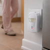 Ultrasonic Pest Plug-In Repellent on a wall with a person's feet in the background