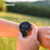 Person wearing a smartwatch with a blurred natural background, featuring the Polaroid logo.