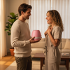 Man and woman in a living room holding a pink and white device